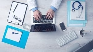 Image of a doctor working at a laptop