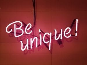 Pink neon sign on wall saying &ldquo;Be Unique.&rdquo; Image via PxHere.com, CC0.