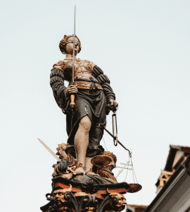 Statue of Lady Justice, blindfolded, holding sword and scale; image by Joel & Jasmin F&oslash;restbird, via unsplash.com.
