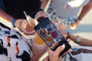 Person taking a picture of mixed drinks; image by David Calder&oacute;n, via Unsplash.com.