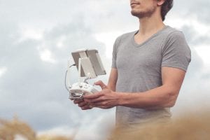 Man holding white and gray drone controller; image by Christian Langenhan, via Unsplash.com.