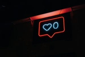 Blue and red neon sign showing the &ldquo;Like&rdquo; count of a social media post; image by Prateek Katyal, via Unsplash.com.