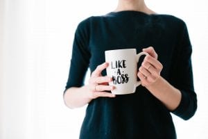 Woman holding white mug that says, &ldquo;Like a Boss;&rdquo; image by Brooke Lark, via Unsplash.com.