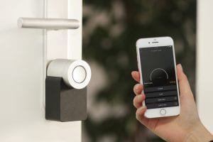 Nuki smart lock with iPhone; image by Sebastian Scholz (Nuki), via Unsplash.com.