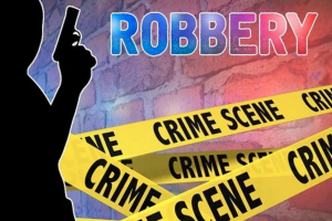 Graphic of man with gun, crime scene tape, and the word &ldquo;Robbery&rdquo; against a brick wall; graphic by 1800420Laws, via Pixabay.com.