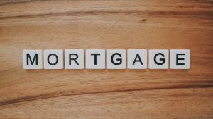 Scrabble tiles spelling out &ldquo;Mortgage&rdquo; on a light wooden background; image by Preconodo CA, via Unsplash.com.