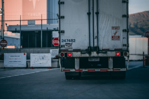 Rear view of a white semi-truck; image by Craig Adderley, via Pexels.com.