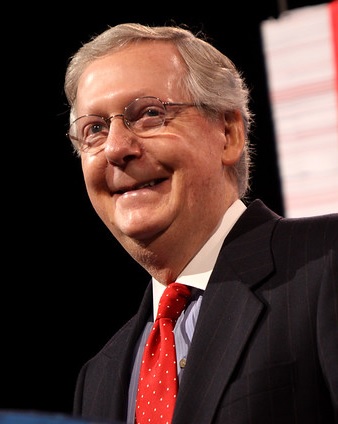 A smiling man in a dark suit.