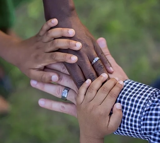 Diverse hands support each other.