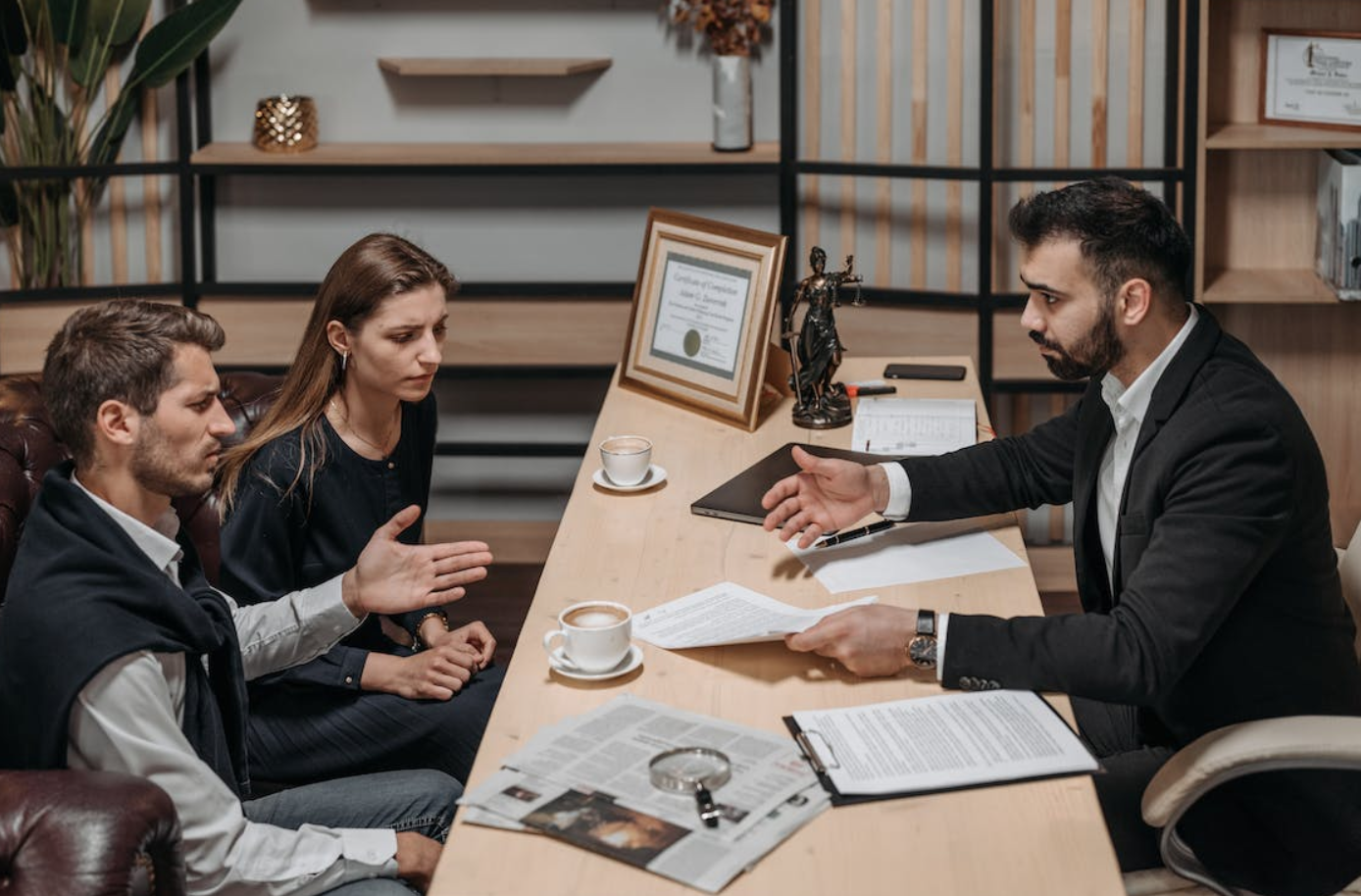 Male lawyer talking to clients; image by Pavel Danilyuk, via Pexels.com.