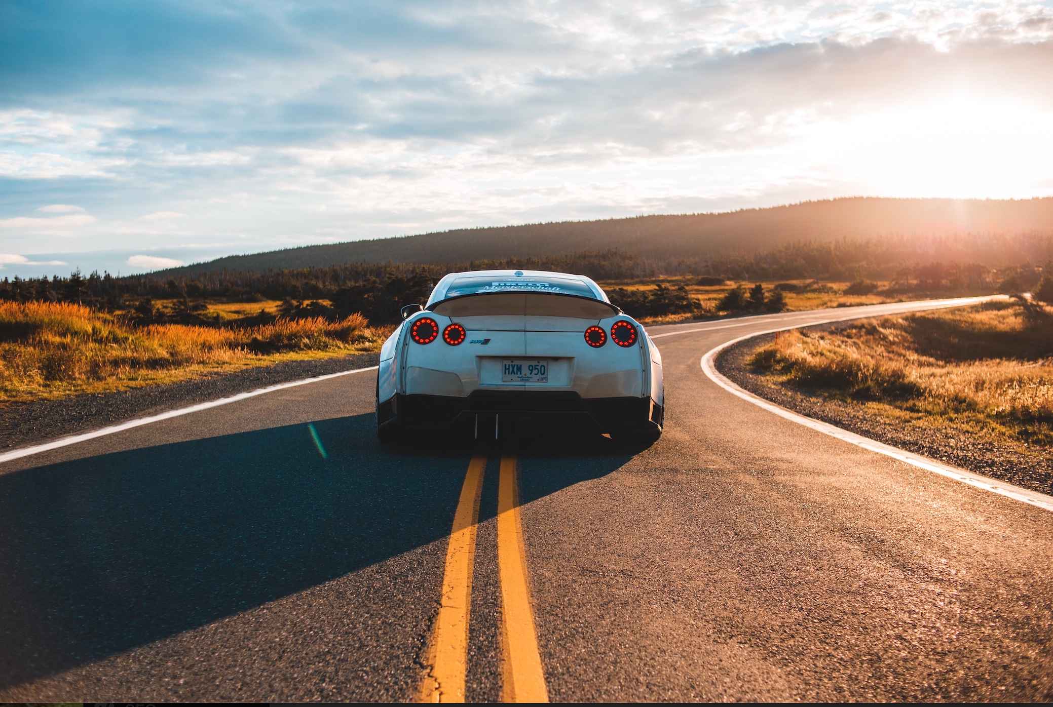 Silver sportscar crossing the double yellow line; image by Erik McLean, via Unsplash.com.