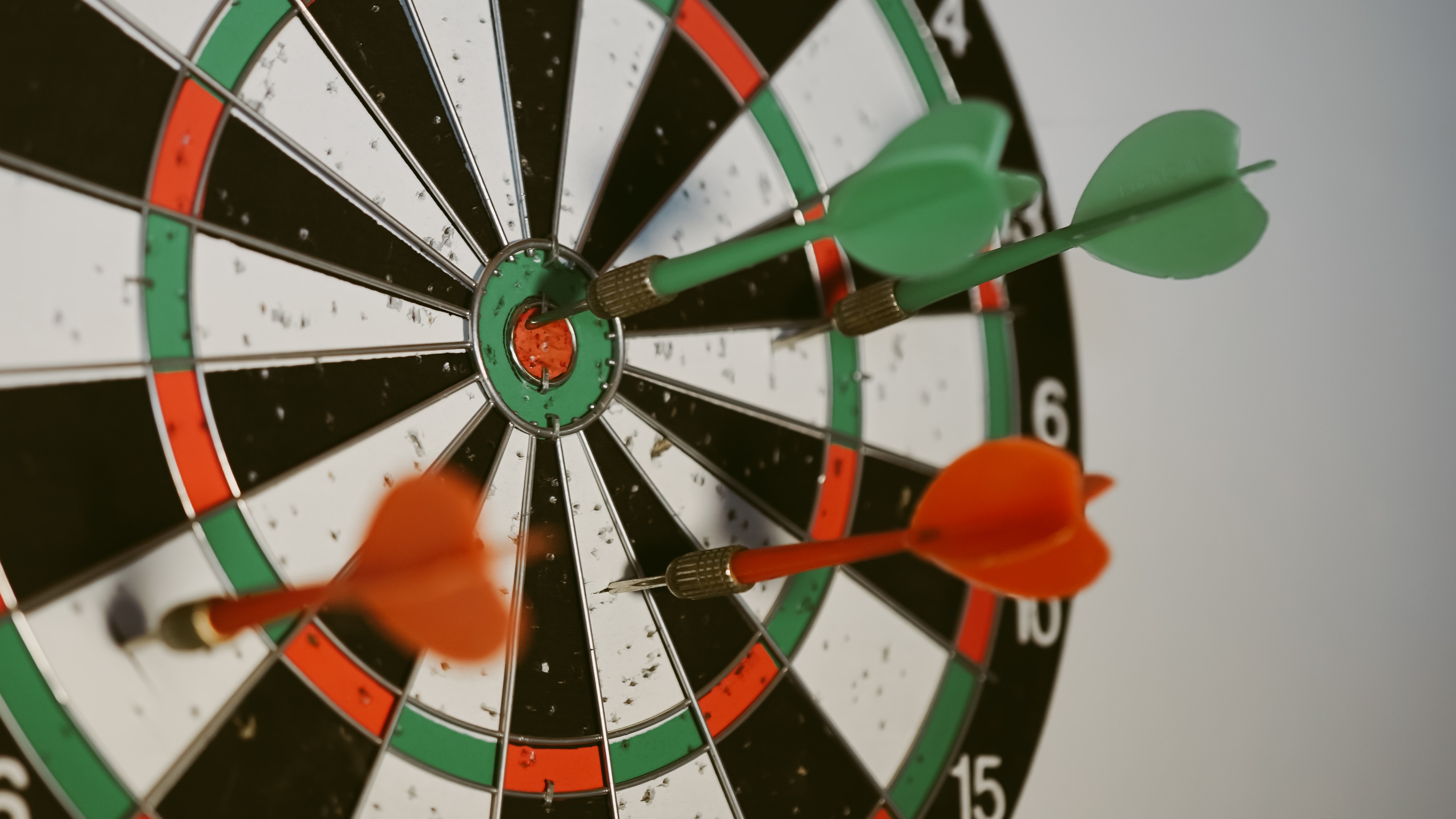 Dartboard with red and green darts; image by Afif Ramdhasuma, via Unsplash.com.