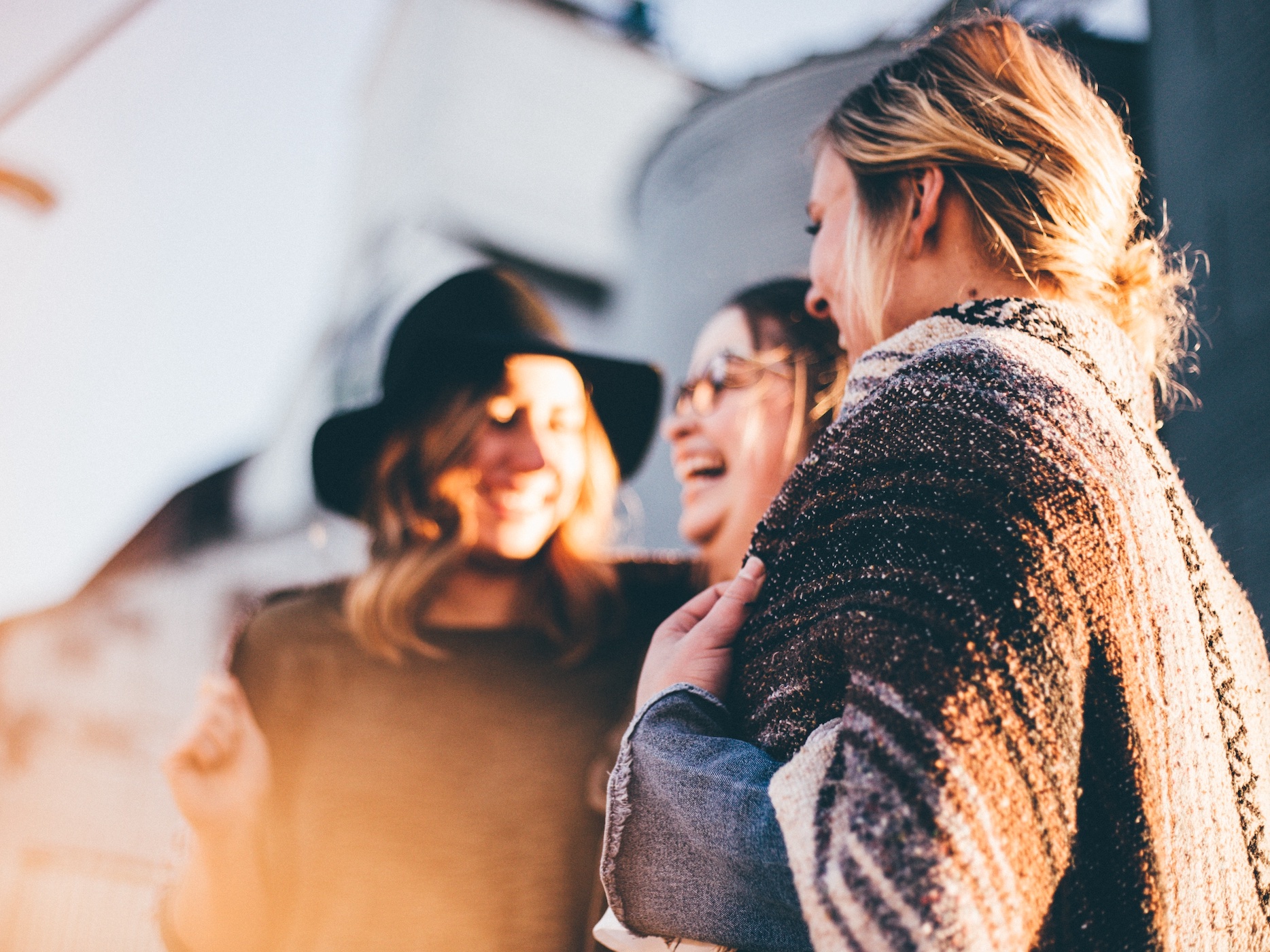 Friends talking outside; image by Priscilla DuPreez, via Unsplash.com.