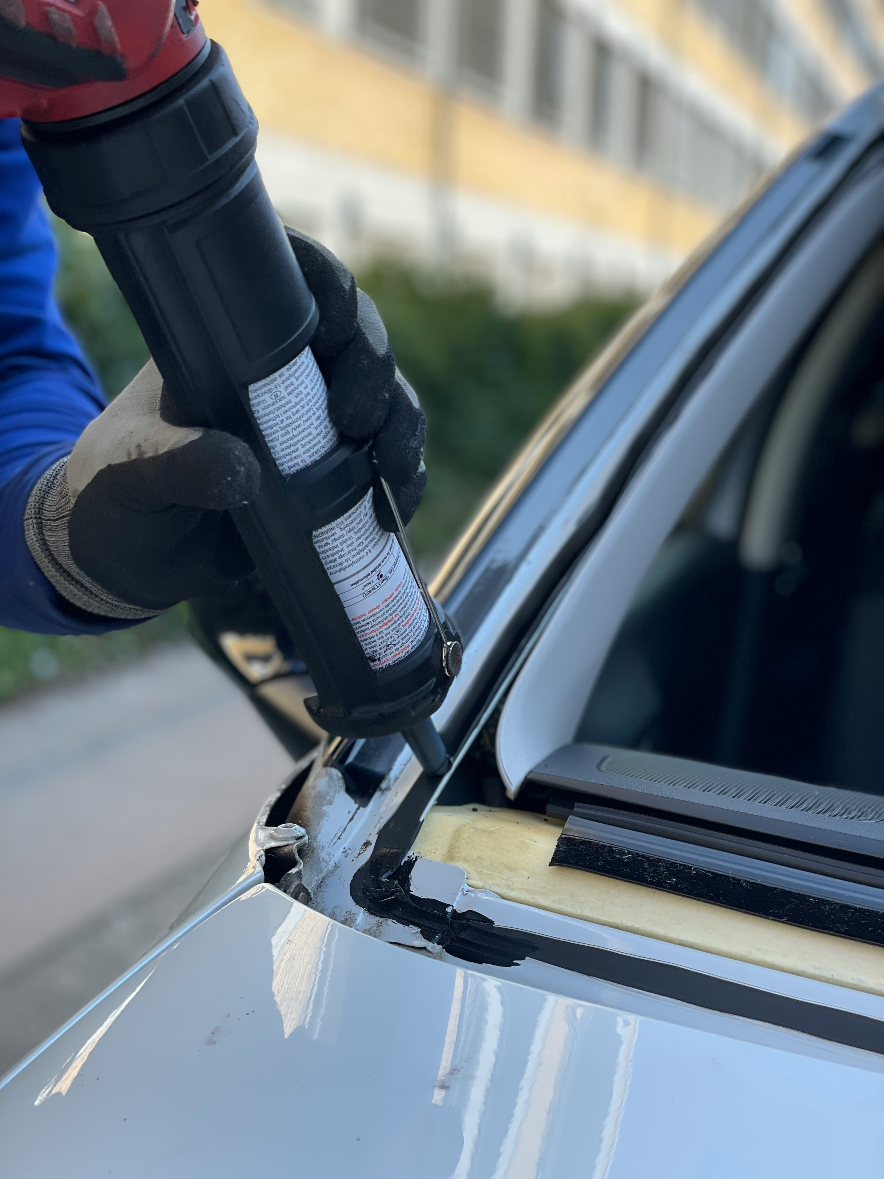 Auto glass technician preparing glue for windscreen replacement; image by UK Car Glass, via Unsplash.com